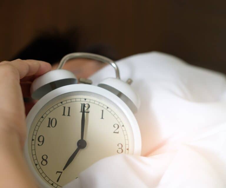 photo of person holding alarm clock