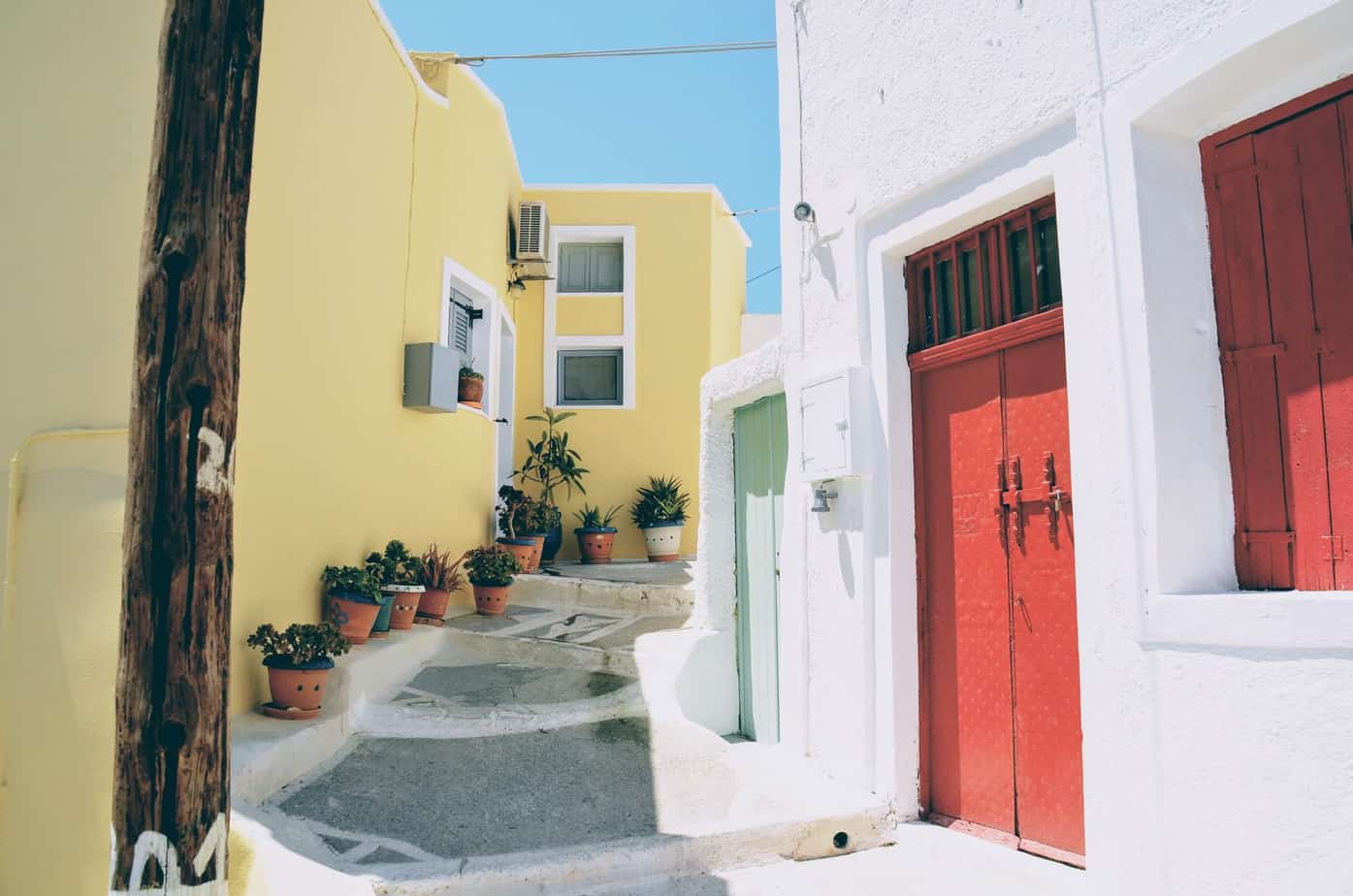 4 Tips For Planning Your Next Tour in Greece | colorful white red and yellow street in Santorini Greece