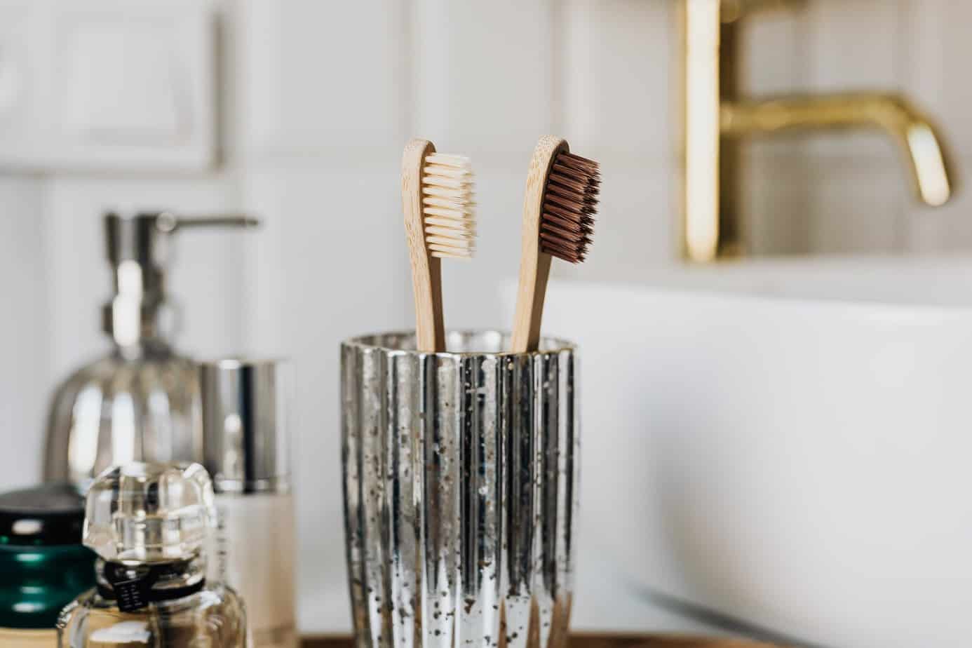 6 Practical bathroom swaps for sustainable living | bamboo toothbrushes in glass in a stylish bathroom