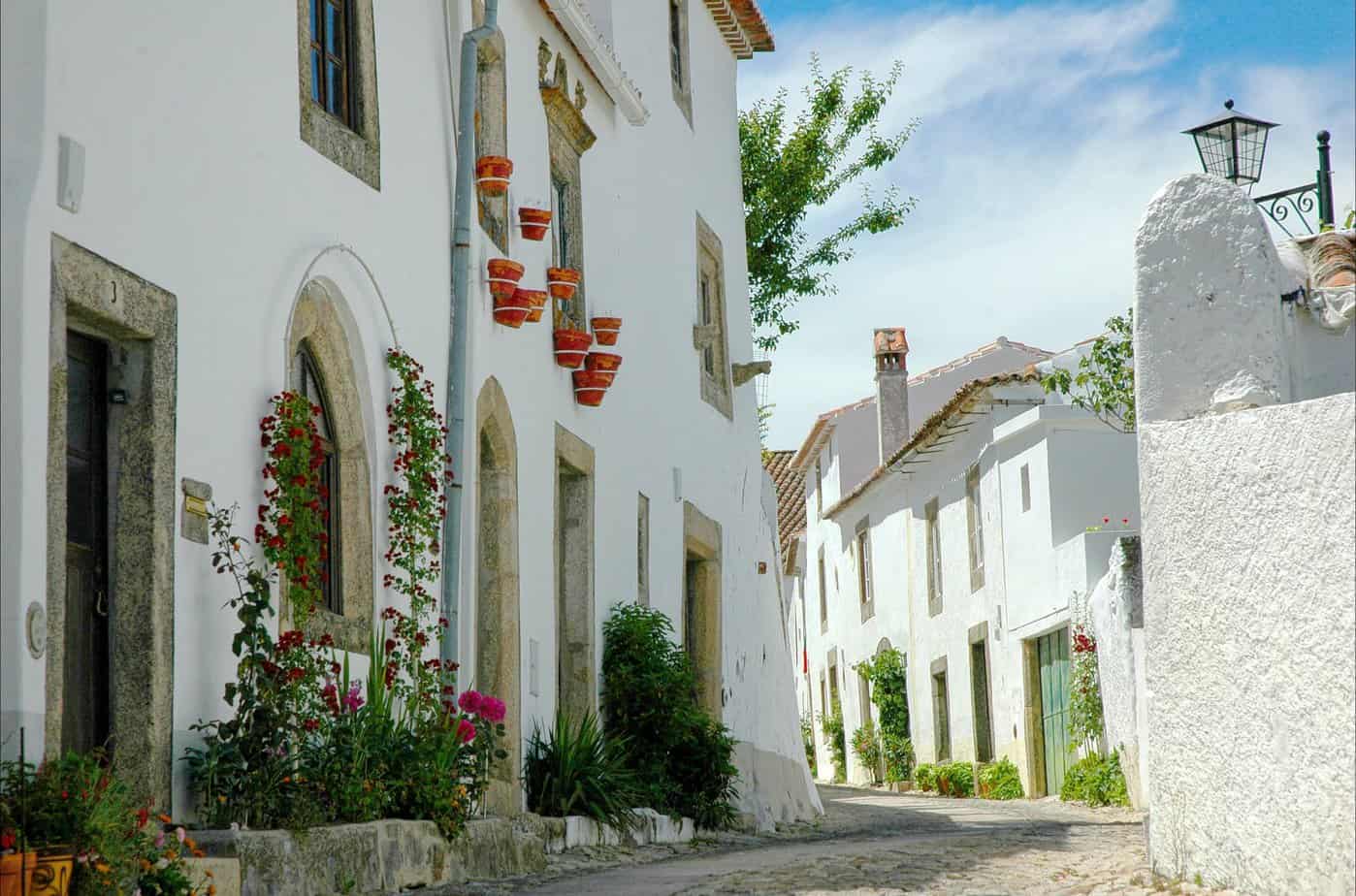 4 Reasons To Head To Portugal Sooner Rather Than Later - white concrete structure with green and red plants