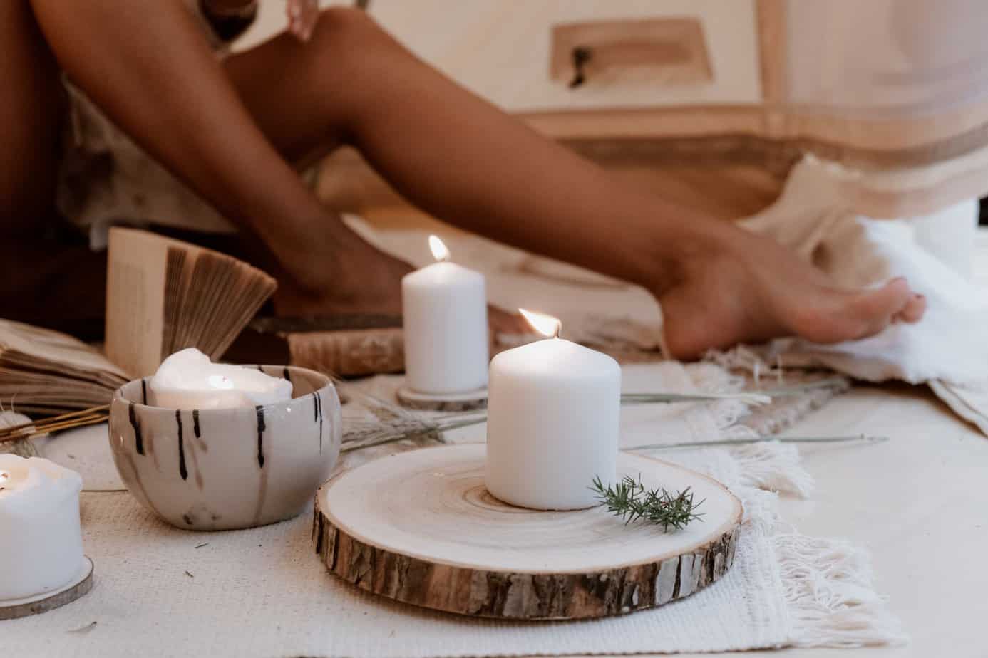 Ways you can Hygge in your living room all year round - white pillar candle on brown wooden round tray