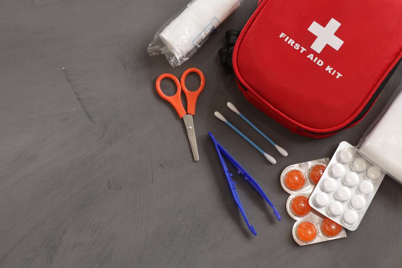 Dealing With a Home Emergency - first aid kit on grey background