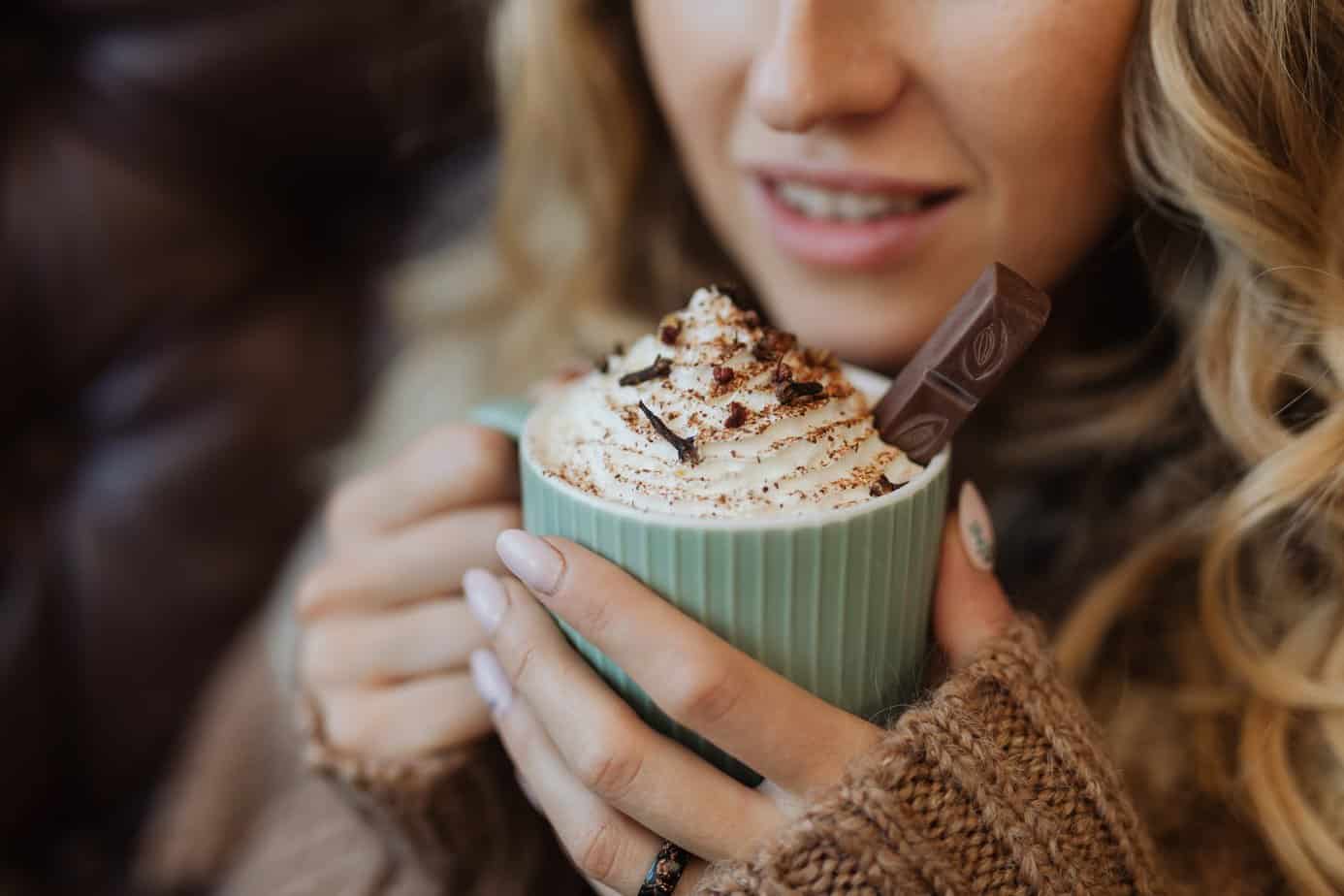 a woman holding a cup of hot cocoa - Ways to recharge after a day on the slopes