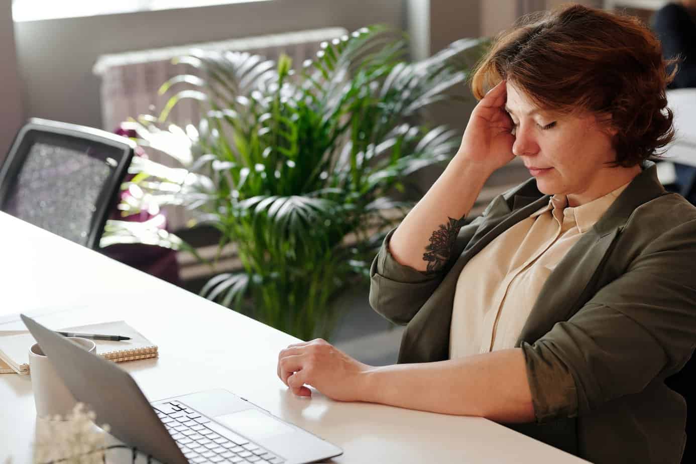 photo of woman holding her head - Stress and Tension Headaches: What causes them?