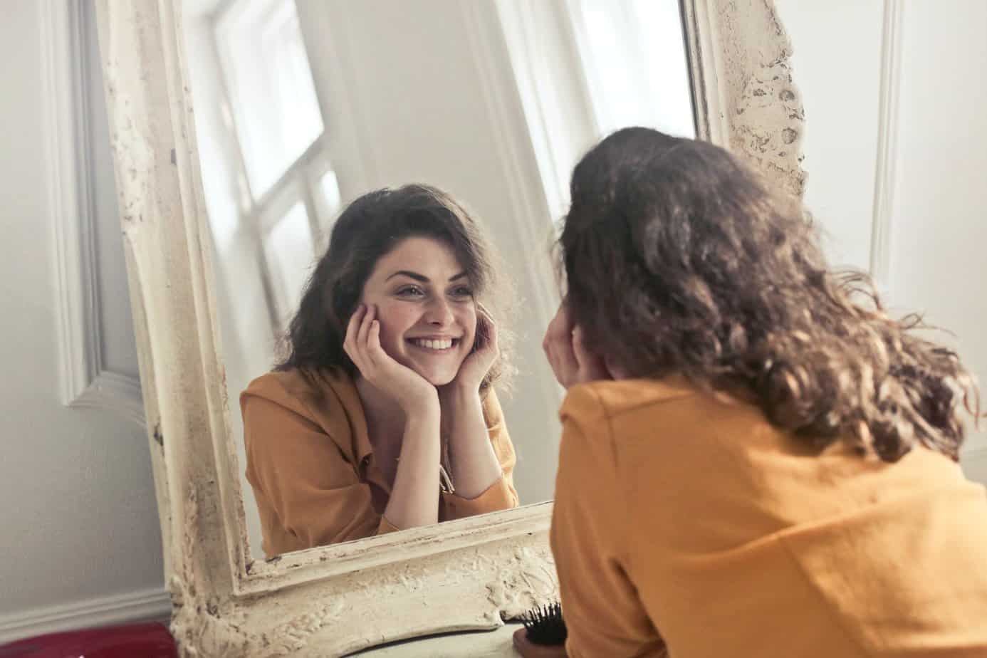 photo of woman looking at the mirror - Quotes that will help you feel more positive